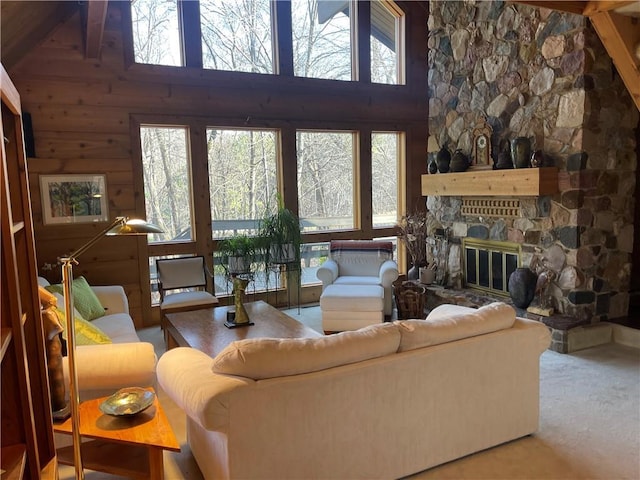 living room with carpet flooring, a wealth of natural light, a fireplace, and high vaulted ceiling