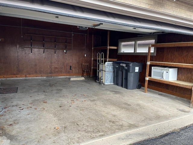 garage with a garage door opener and wood walls