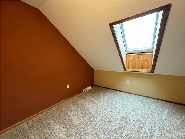 additional living space with carpet floors and lofted ceiling with skylight