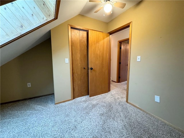 interior space featuring carpet, a closet, vaulted ceiling, and ceiling fan