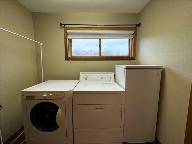 clothes washing area featuring separate washer and dryer and plenty of natural light