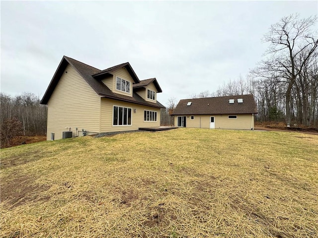 rear view of house with a yard and central air condition unit