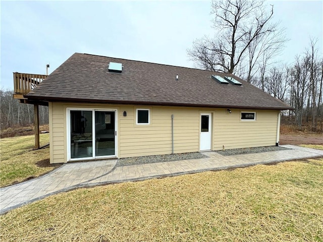 rear view of house with a yard and a patio