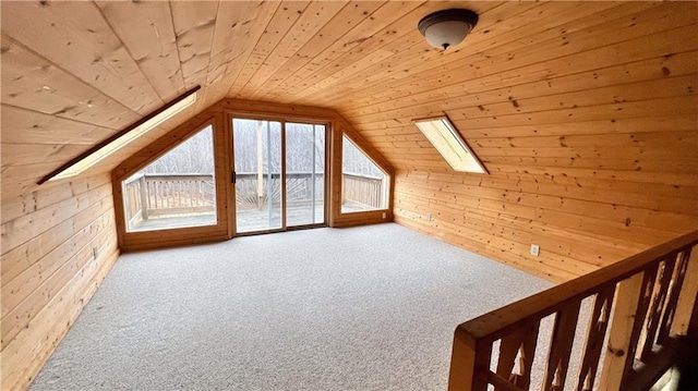 additional living space featuring vaulted ceiling with skylight, carpet flooring, wood walls, and wood ceiling