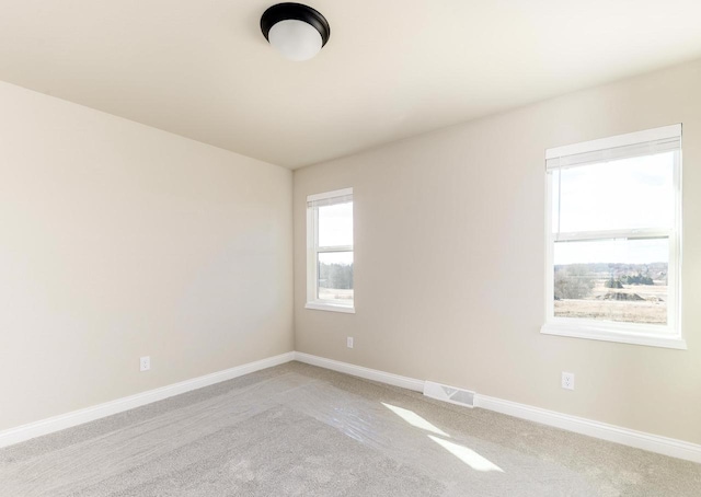 unfurnished room featuring baseboards, visible vents, and light colored carpet