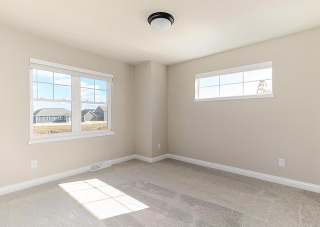 carpeted empty room with baseboards and visible vents