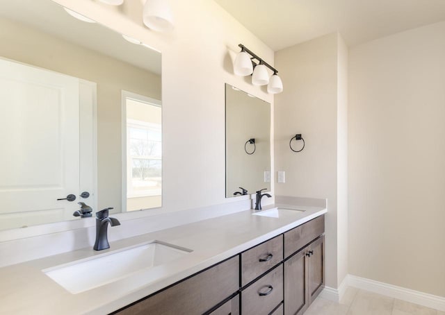 full bathroom featuring double vanity, tile patterned flooring, baseboards, and a sink