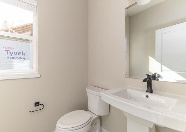 half bath featuring toilet and a sink