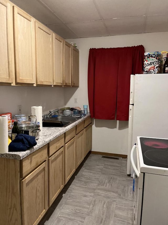 kitchen featuring light brown cabinets, white range oven, and sink