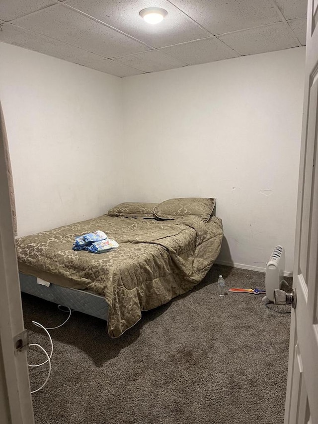 bedroom featuring carpet flooring and a drop ceiling