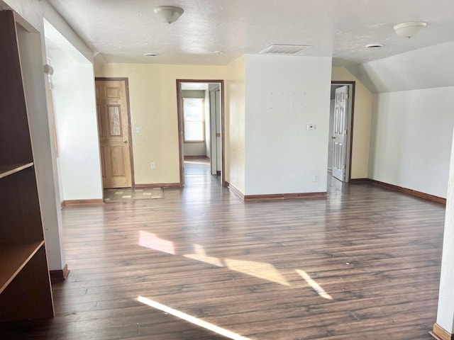 spare room with dark hardwood / wood-style floors and lofted ceiling