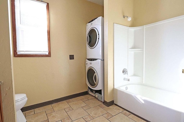 bathroom with shower / bath combination, stacked washing maching and dryer, and toilet