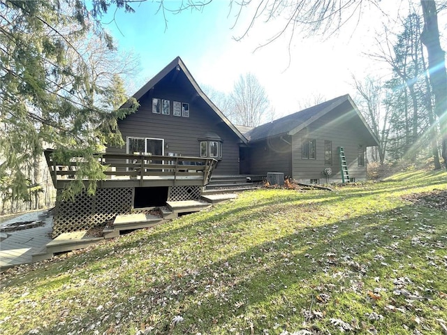 rear view of property with a yard, central AC unit, and a wooden deck