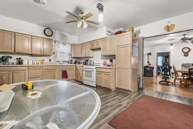 kitchen with light brown cabinetry, a textured ceiling, dark hardwood / wood-style flooring, and white gas range oven