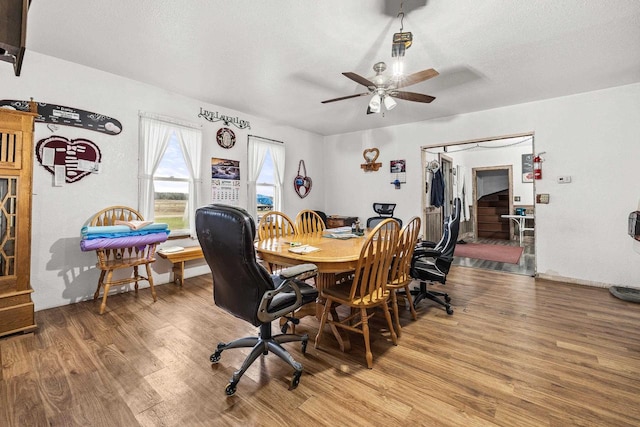 dining area with a textured ceiling, ceiling fan, and wood-type flooring