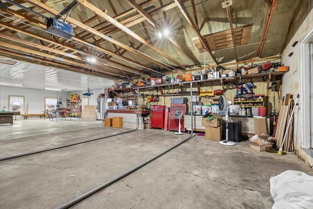 interior space with water heater, a garage door opener, and a workshop area