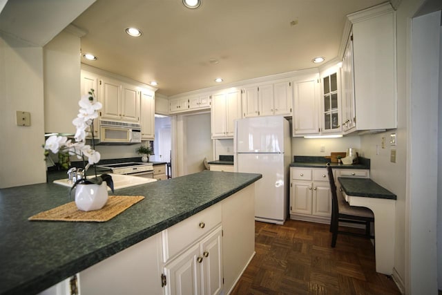 613 College St, Beloit, WI 53511 - kitchen featuring white appliances, dark countertops, recessed lighting, and white cabinetry