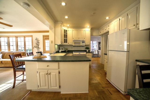 613 College St, Beloit, WI 53511 - kitchen with white appliances, dark countertops, recessed lighting, a sink, and ornamental molding