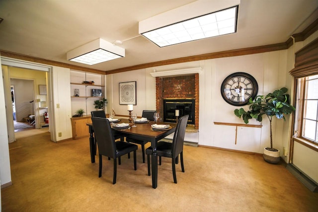 613 College St, Beloit, WI 53511 - dining area featuring light colored carpet, a fireplace, and ornamental molding