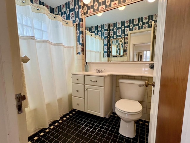 613 College St, Beloit, WI 53511 - bathroom featuring wallpapered walls, toilet, plenty of natural light, shower / tub combo with curtain, and tile patterned floors