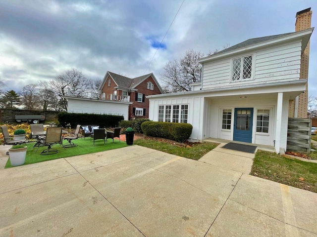 613 College St, Beloit, WI 53511 - view of front of property featuring a patio, a chimney, and outdoor dining area