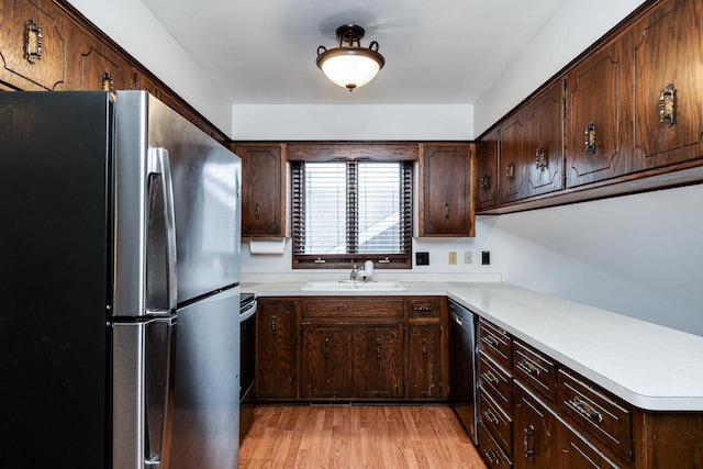 kitchen with sink, dark brown cabinets, stainless steel fridge, and light hardwood / wood-style floors