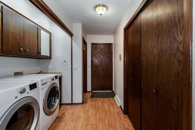 clothes washing area featuring baseboard heating, cabinets, light hardwood / wood-style floors, and washing machine and clothes dryer