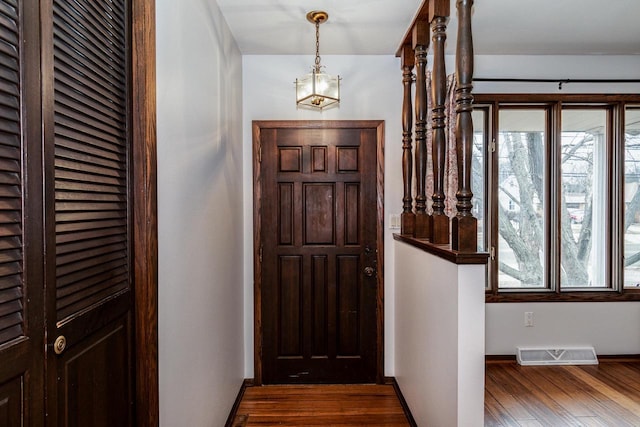 foyer entrance with dark wood-type flooring and plenty of natural light