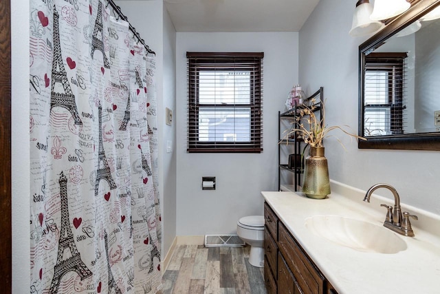 bathroom featuring hardwood / wood-style flooring, vanity, a shower with shower curtain, and toilet