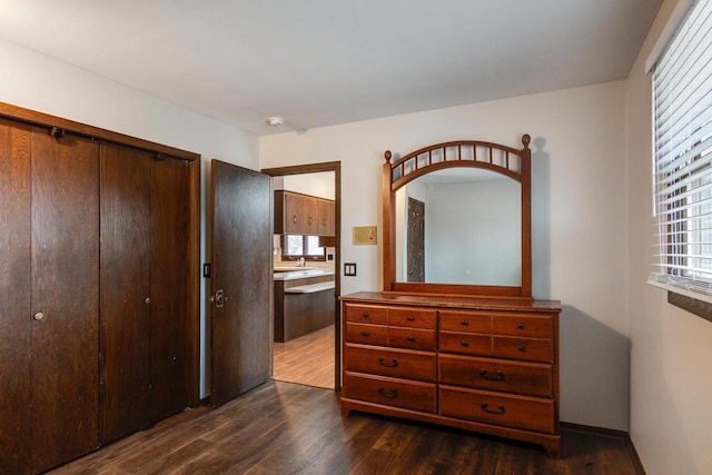 bedroom with dark hardwood / wood-style flooring and a closet