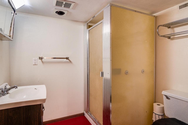 bathroom with a shower with door, vanity, and toilet