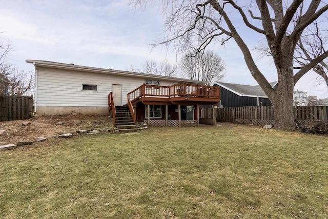 rear view of house featuring a wooden deck and a lawn