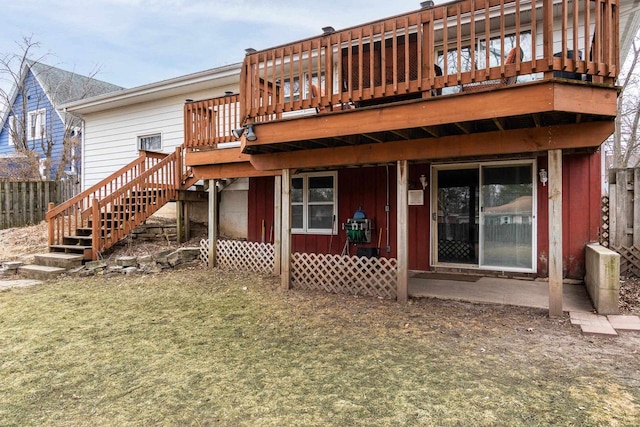 rear view of house featuring a lawn and a deck