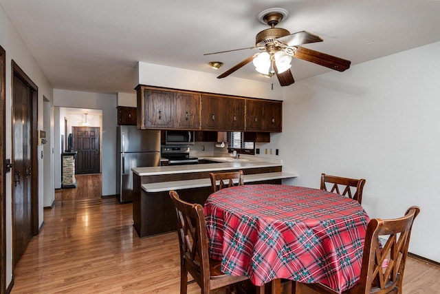 dining area with ceiling fan and light hardwood / wood-style flooring