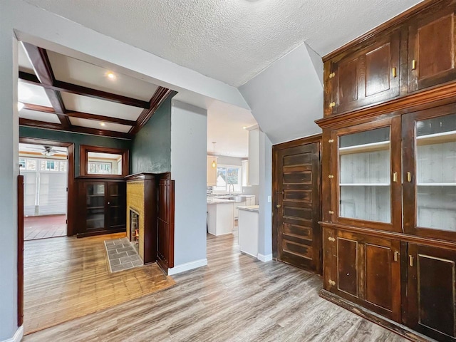 interior space featuring coffered ceiling, ceiling fan, beam ceiling, and light hardwood / wood-style flooring