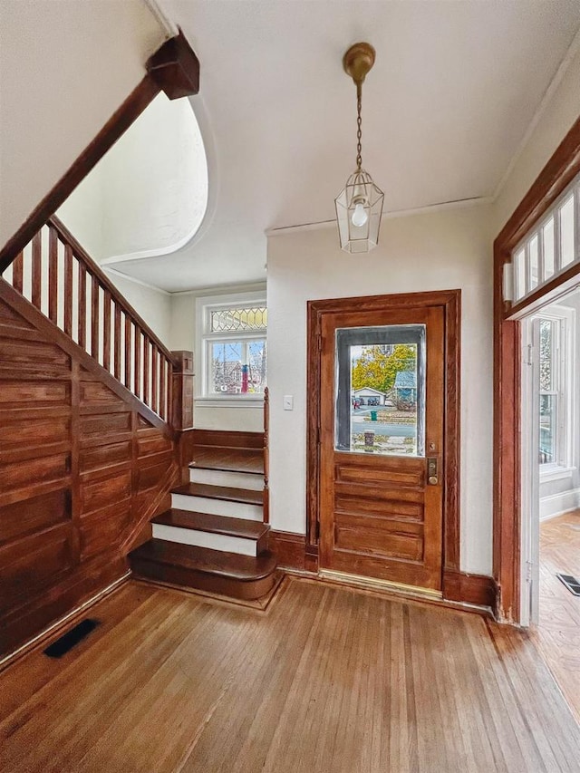 entrance foyer featuring wood-type flooring and crown molding
