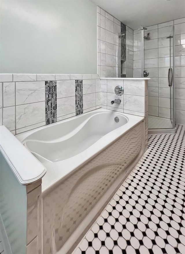 bathroom with tile walls and plus walk in shower