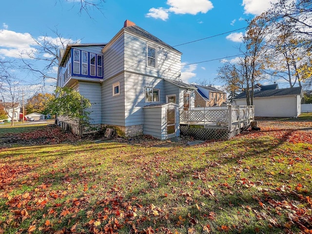 back of house featuring a lawn and a wooden deck
