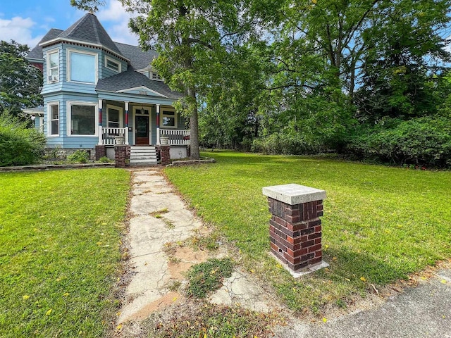 view of front of house with covered porch and a front lawn