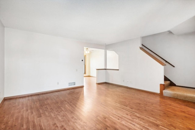 unfurnished living room featuring wood-type flooring and ceiling fan