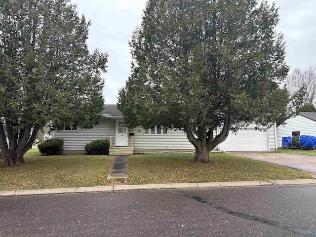 obstructed view of property with a garage and a front lawn