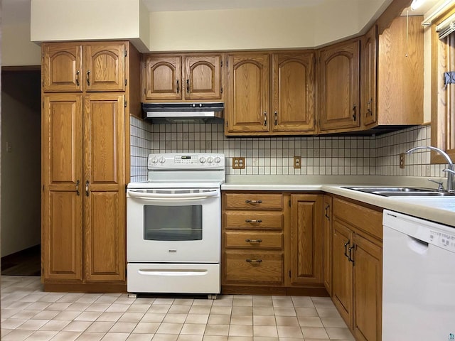 kitchen featuring white appliances, backsplash, and sink