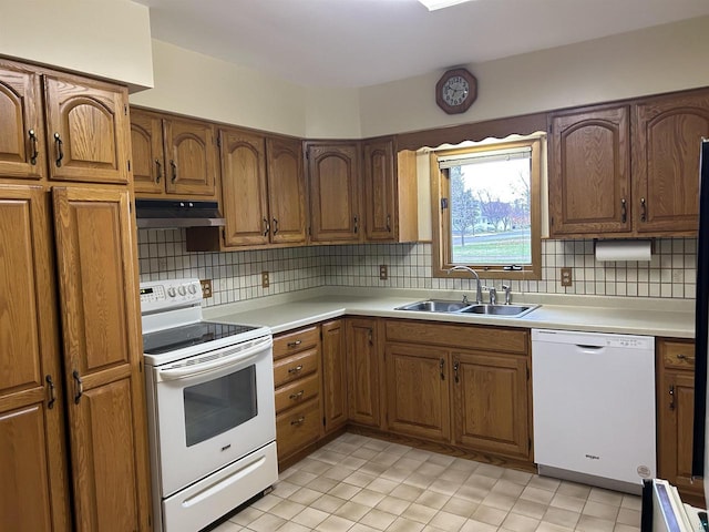 kitchen featuring backsplash, sink, and white appliances