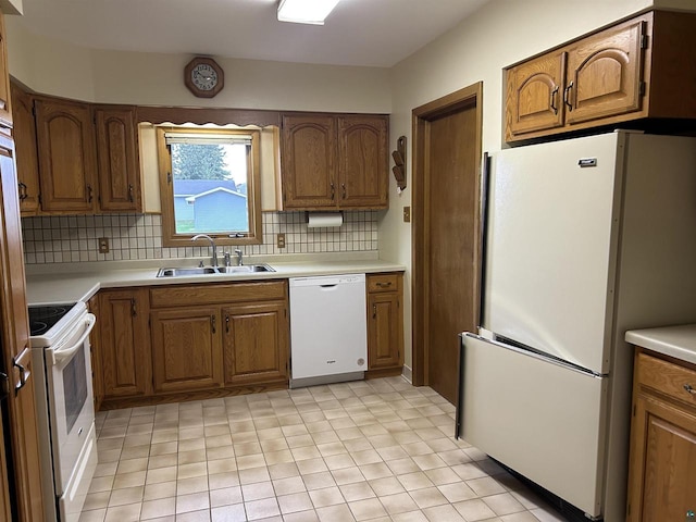 kitchen featuring backsplash, sink, and white appliances