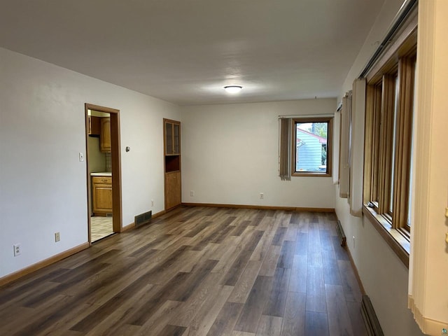 unfurnished bedroom featuring dark hardwood / wood-style floors and ensuite bath