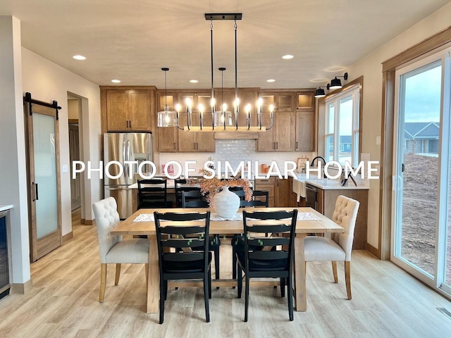 dining space with a barn door, recessed lighting, beverage cooler, baseboards, and light wood finished floors