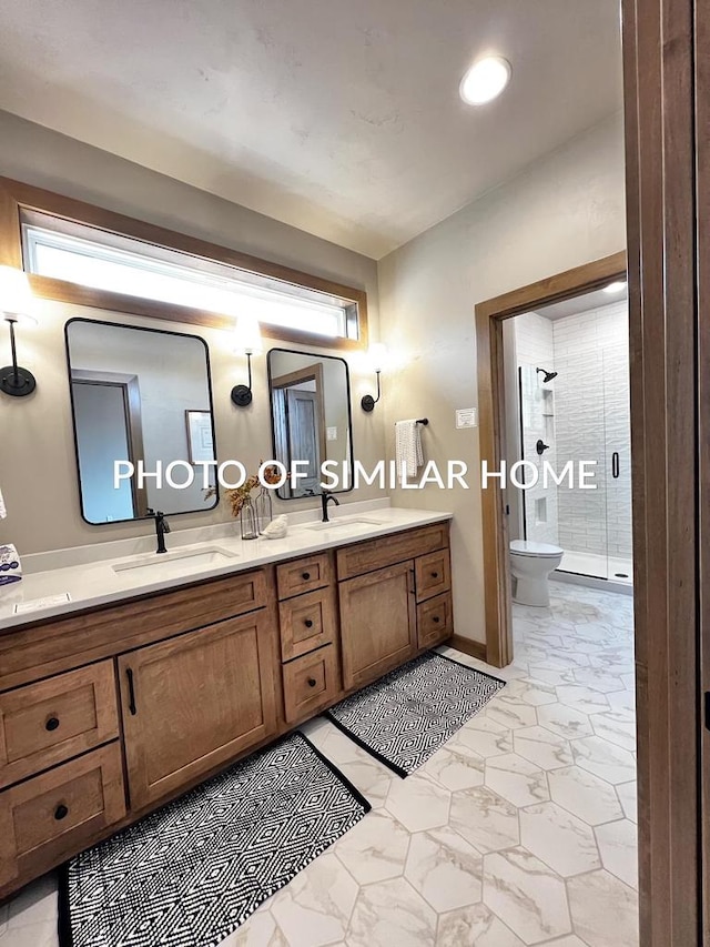 full bathroom featuring double vanity, a sink, toilet, and a shower stall