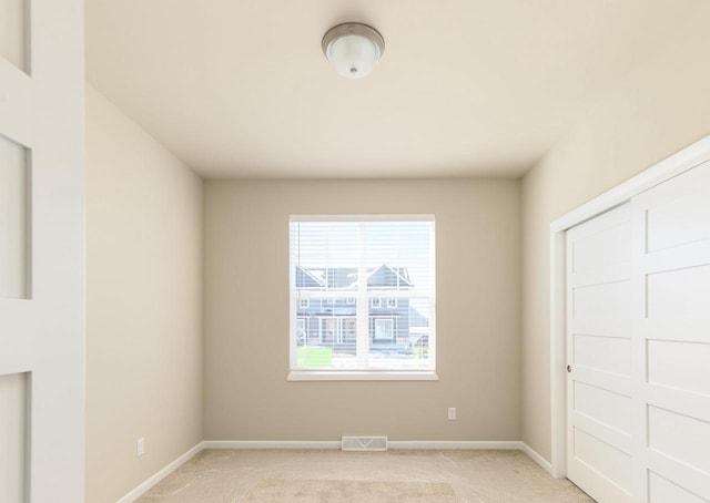 interior space featuring light carpet, baseboards, and visible vents