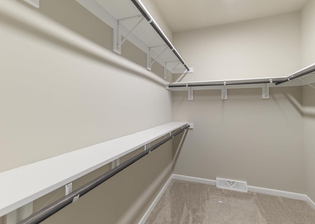 walk in closet with light colored carpet and visible vents