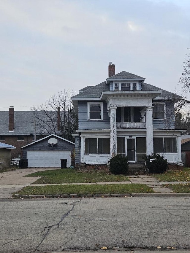 greek revival house featuring a balcony, a front lawn, an outdoor structure, and a garage